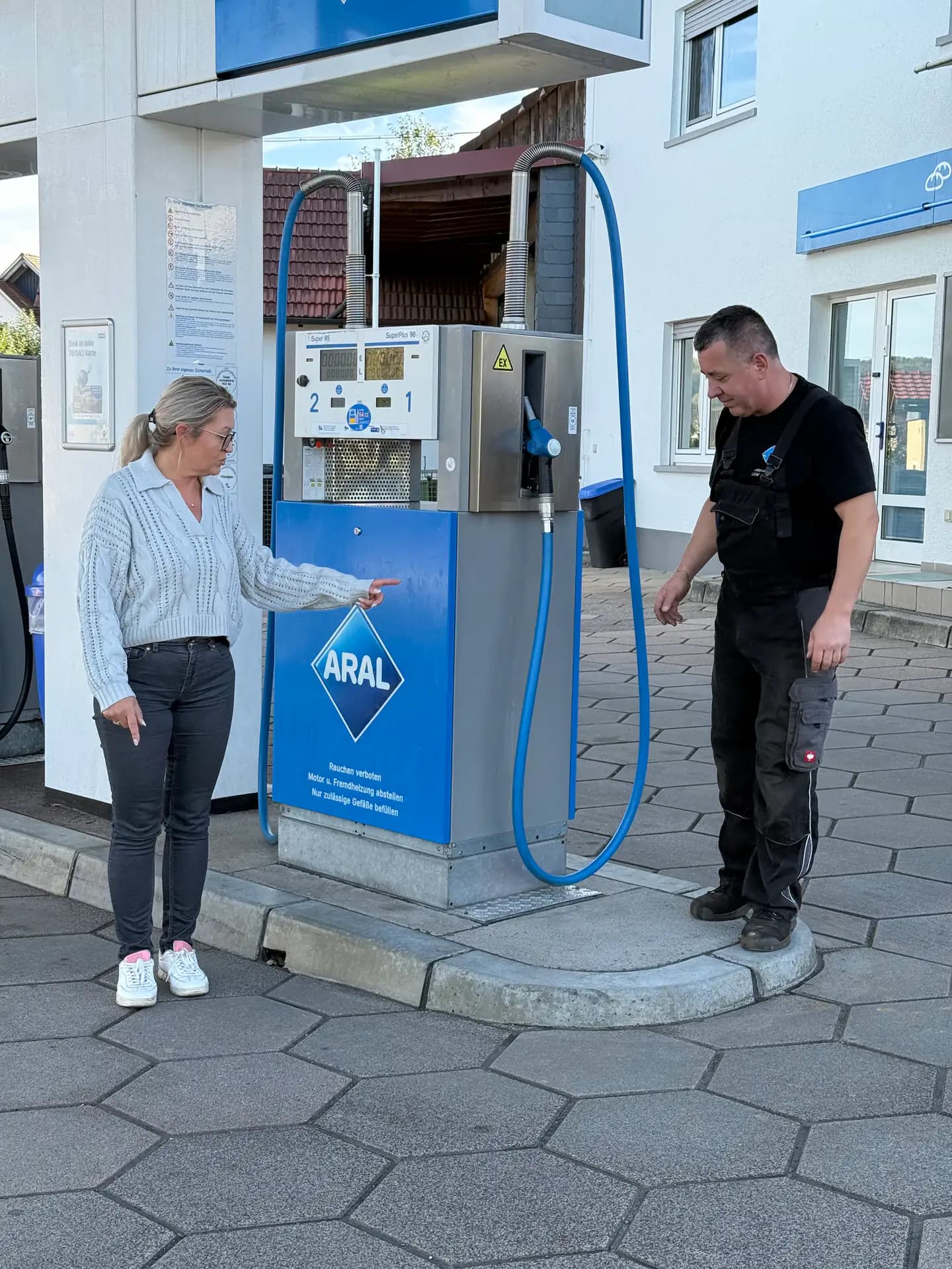 Unsere Kollegin und Zbigniew Suchecki an einer Zapfsäule der Aral-Tankstelle