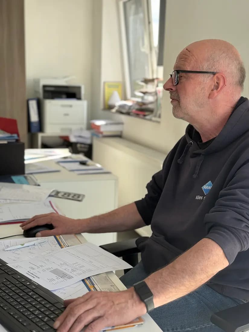 Mitarbeiter bei der Planung am Schreibtisch der Reparaturannahme