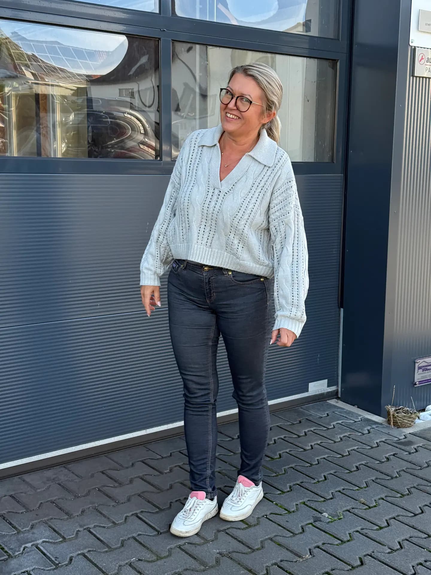 Unsere Kollegin lachend vor der Werkstatt in Gedern